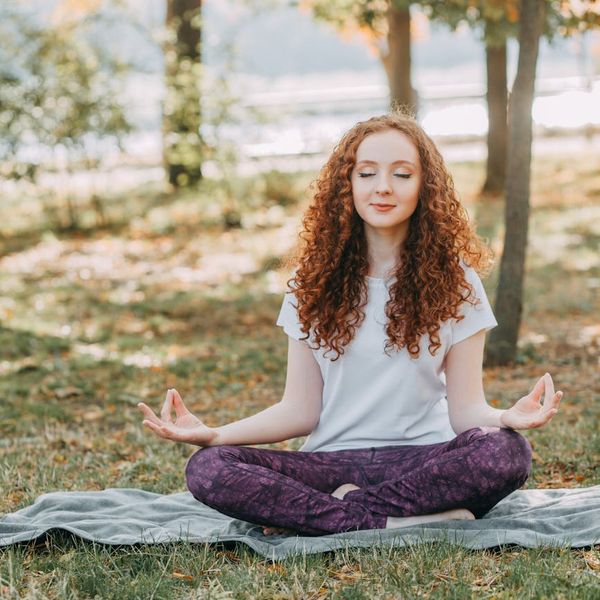 Person in a state of calm balance during exercise, surrounded by nature elements.